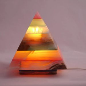 Lampe en onyx forme pyramidale sur fond blanc éclairée