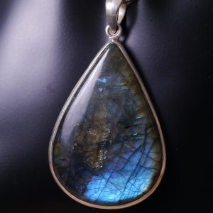 Zoom pendentif en argent et pierre en labradorite en forme de goutte. On y voit ses reflets bleus foncés ou bleu clair intense selon la lumière